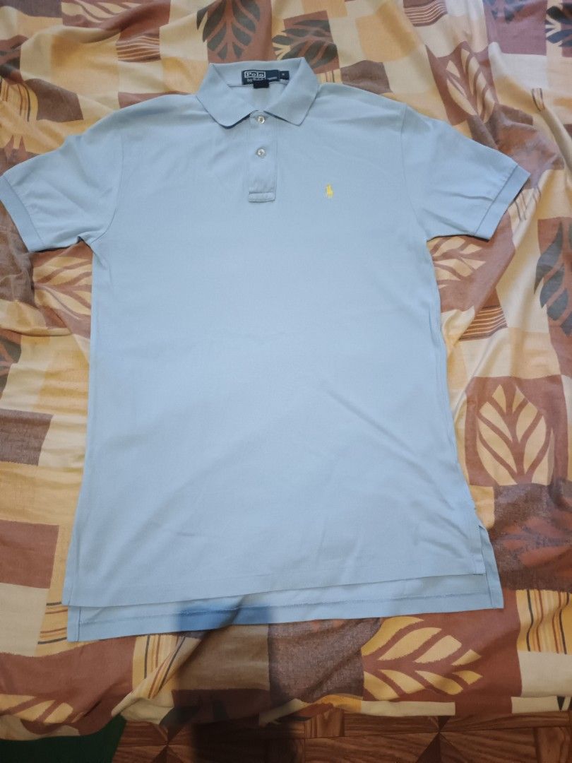 Polo Ralph Lauren (Category: Activewear) located in Odiongan. Submitted by thriftngo26 (Listing ID 1469403263, Image 1). Description: This is a classic Polo Ralph Lauren light blue piqué polo shirt featuring the signature yellow embroidered Polo Pony motif on the chest. This short-sleeve style includes a two-button placket, ribbed collar, and small side slits at the hem.