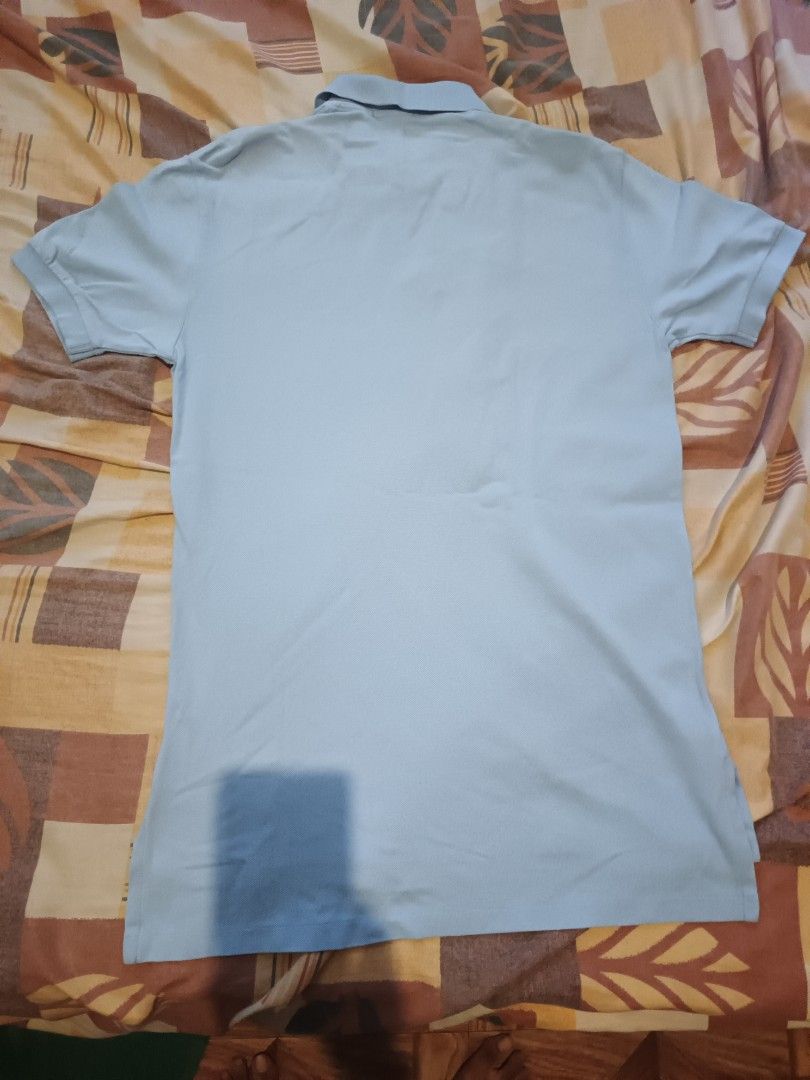 Polo Ralph Lauren (Category: Activewear) located in Odiongan. Submitted by thriftngo26 (Listing ID 1469403263, Image 3). Description: This is a classic Polo Ralph Lauren light blue piqué polo shirt featuring the signature yellow embroidered Polo Pony motif on the chest. This short-sleeve style includes a two-button placket, ribbed collar, and small side slits at the hem.
