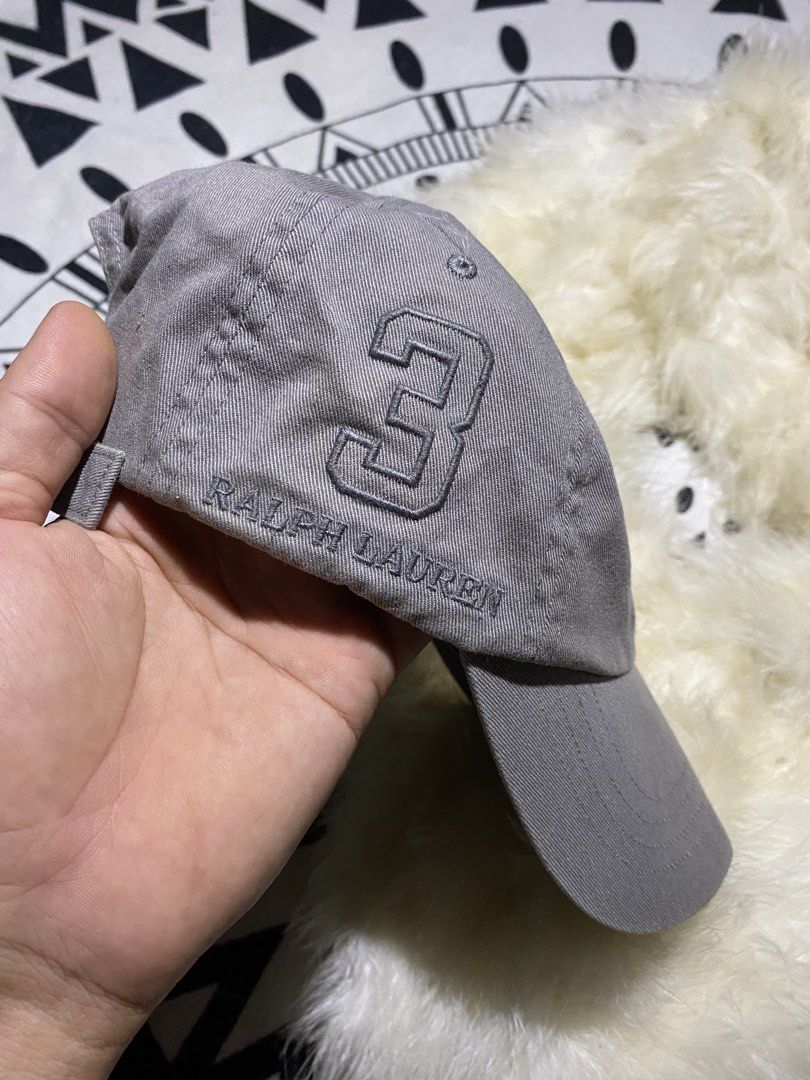 Polo Ralph Lauren Grey Baseball Cap (Category: Caps & Hats) located in Badiangan. Submitted by iralorana.thrift (Listing ID 1469419499, Image 3). Description: - Brand: Ralph Lauren - Color: Classic Grey - Details: Embroidered front logo, signature number 3 on the right side, and POLO text above the back strap - Fit: Adjustable metal buckle closure with a curved brim.