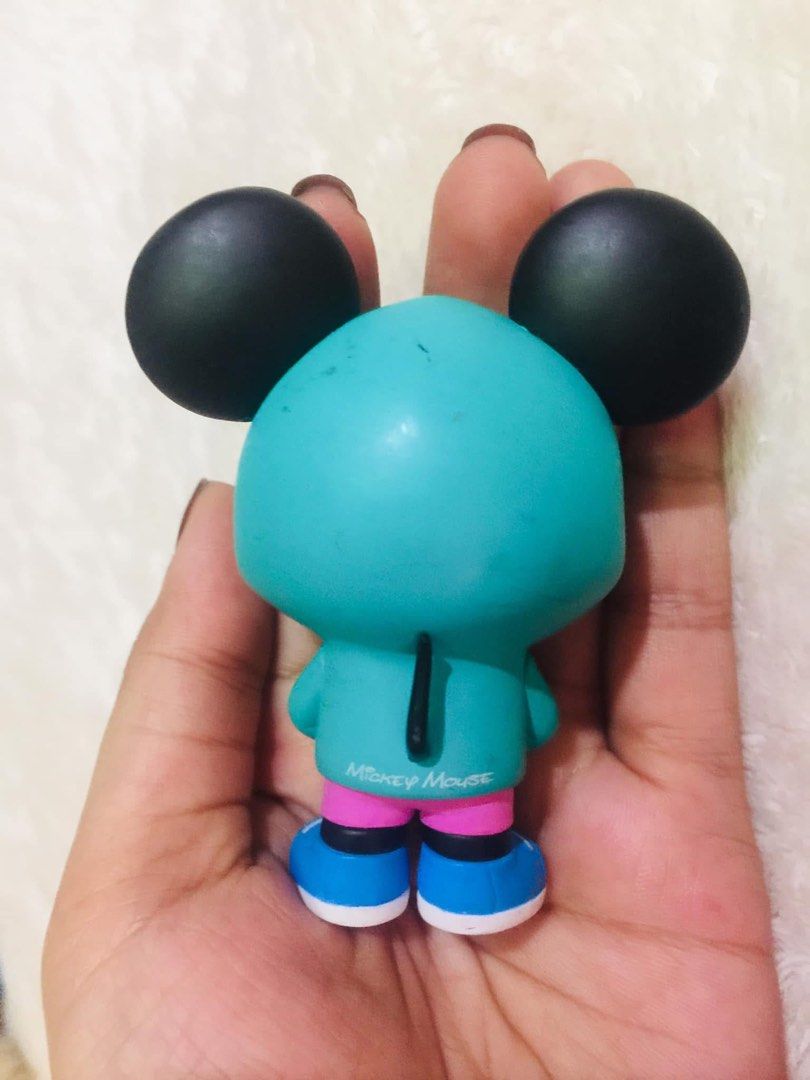 POP MART Disney Mickey Mouse Vinyl Figure (Category: Designer & Blind Box Toys) located in Baguio. Submitted by izza_thrifty (Listing ID 1469567910, Image 3). Description: - Authentic Pop Mart Disney Mickey Mouse vinyl figure - Stylish outfit: teal hoodie with Mickey logo on the back, pink shorts, and blue sneakers - Features authentic stamps printed on the bottom of the shoes - Stands upright easily for display - Condition: Shows light scuffs an