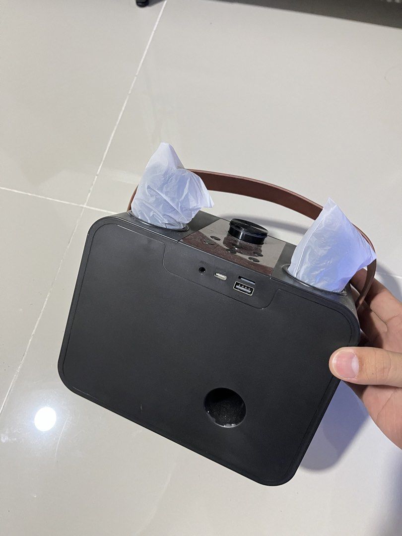 RUSH SALE Portable Bluetooth Speaker with Leather Handle and Volume Knob - NEGO (Category: Soundbars, Speakers & Amplifiers) located in Manila. Submitted by curated.clutter12 (Listing ID 1469516232, Image 2). Description: - Color & Design: Sleek black finish with a premium brown leather carrying strap - Controls: Features a large volume dial and multiple easy-access buttons on the top panel - Connectivity & Ports: Equipped with an auxiliary jack,