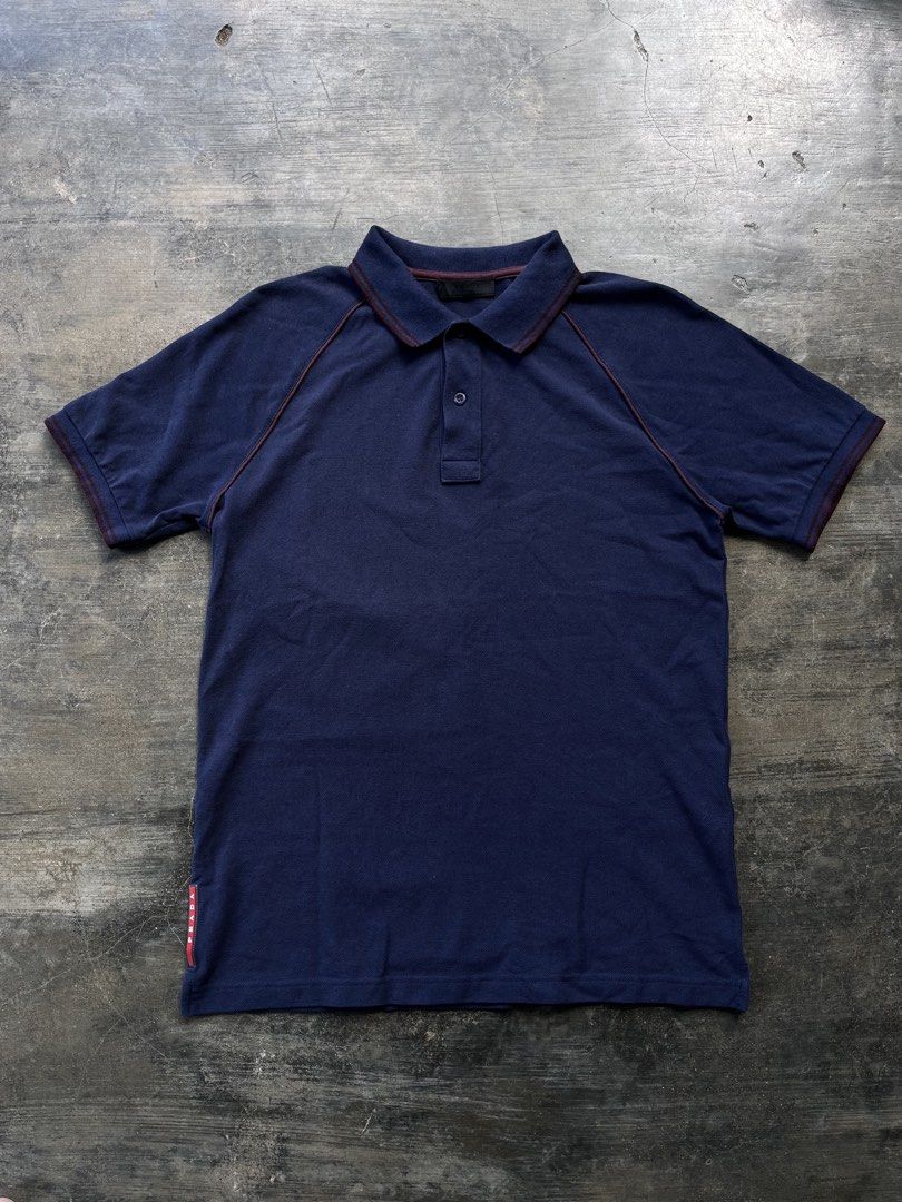 Pr4da Navy Blue Polo Shirt (Category: Tshirts & Polo Shirts ) located in Kalibo. Submitted by notdavaaa (Listing ID 1469498337, Image 1). Description: Size: Medium fittings Dimes: W: 19 L: 27 Excellent condition, cut washtag Color Rate: 9.8/10.