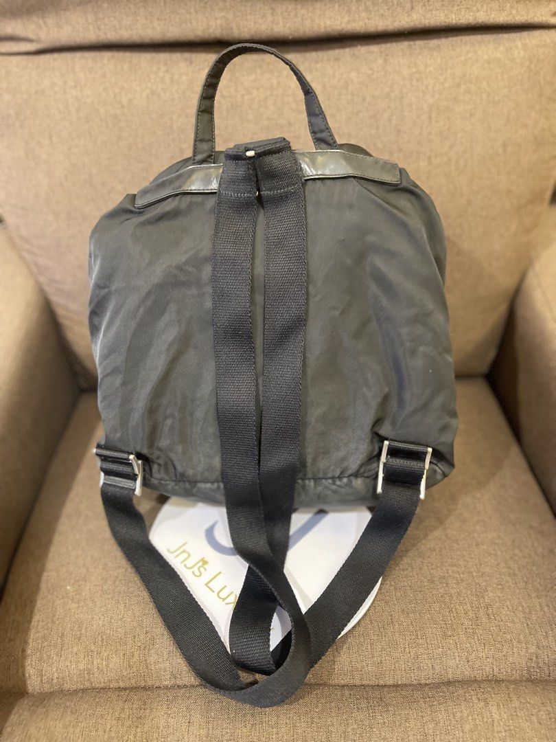 Prada Black Nylon Backpack (Category: Backpacks) located in Manila. Submitted by jnjsluxury (Listing ID 1469455117, Image 3). Description: - Brand: Prada - Material: Classic black nylon with leather trim - Logo: Iconic metal triangle logo plate - Closure: Drawstring under flap with secure buckle straps - Pockets: Two exterior pockets for easy access - Straps: Adjustable black webbed shoulder straps and top handle - Condition: heavily used with fl