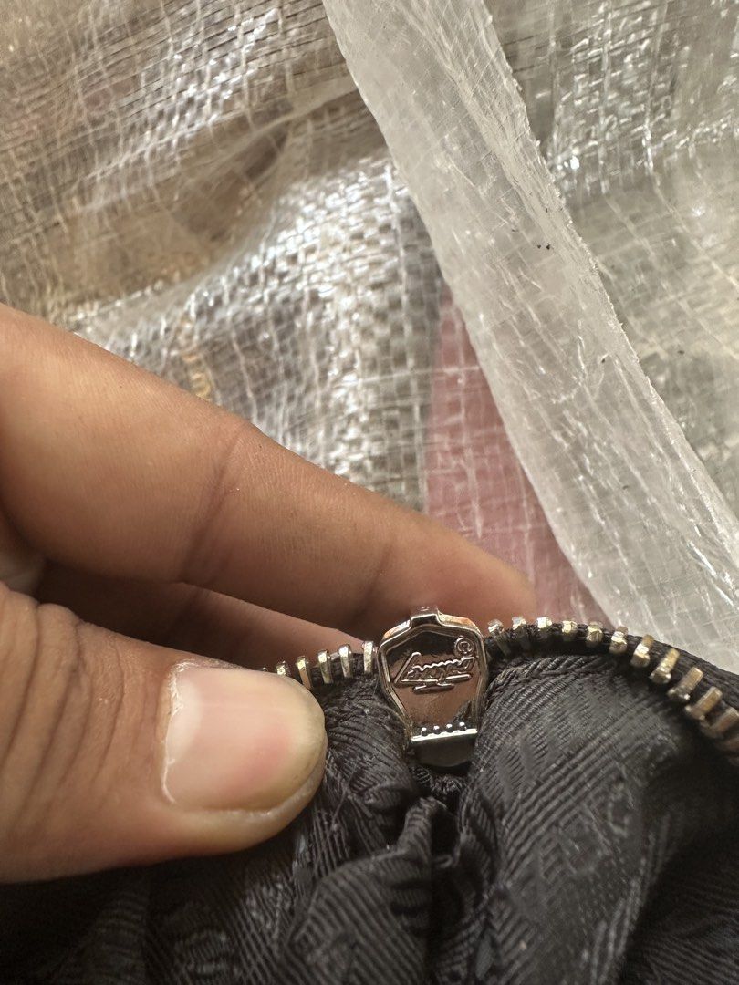 Prada Black Nylon Mini Bag with Chain Strap (Category: Luxury Bags & Wallets) located in Digos. Submitted by reywearfinds (Listing ID 1469484231, Image 2). Description: - Authentic Prada black nylon mini handbag - Chic silver chain shoulder strap and logo-engraved zipper pull - Iconic Prada metal triangle logo plaque on the front - Stylish interior lining with repeated brand lettering - Includes interior 'Made in Italy' tag (number 165) - Clean c