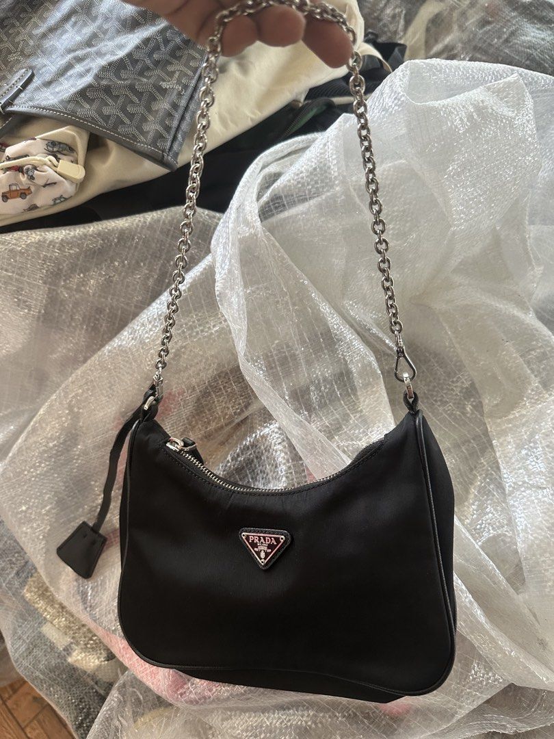 Prada Black Nylon Mini Bag with Chain Strap (Category: Luxury Bags & Wallets) located in Digos. Submitted by reywearfinds (Listing ID 1469484231, Image 1). Description: - Authentic Prada black nylon mini handbag - Chic silver chain shoulder strap and logo-engraved zipper pull - Iconic Prada metal triangle logo plaque on the front - Stylish interior lining with repeated brand lettering - Includes interior 'Made in Italy' tag (number 165) - Clean c