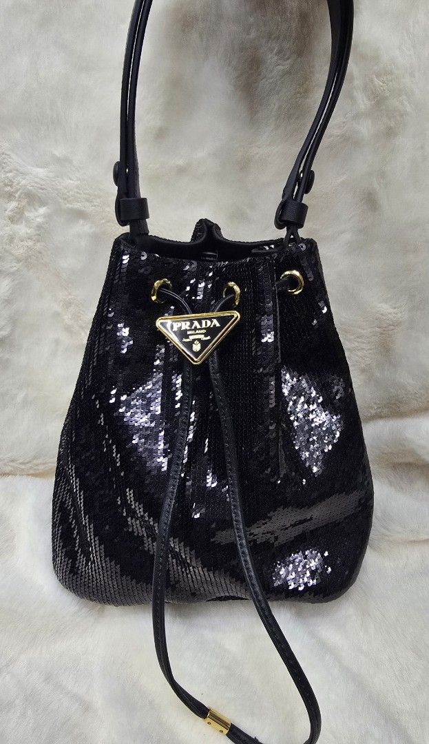 Prada Black Sequin Bucket Bag (Category: Luxury Bags & Wallets) located in Manila. Submitted by brandedshoppe_mnl (Listing ID 1469490414, Image 1). Description: - Brand: Authentic Prada - Style: Sequin bucket bag - Color/Material: Black sequins with leather handles - Hardware: Gold-tone with classic triangle logo plate - Closure: Drawstring - Structure: Flat bottom base - Condition: Pristine, clean interior and exterior with no missing sequins -E