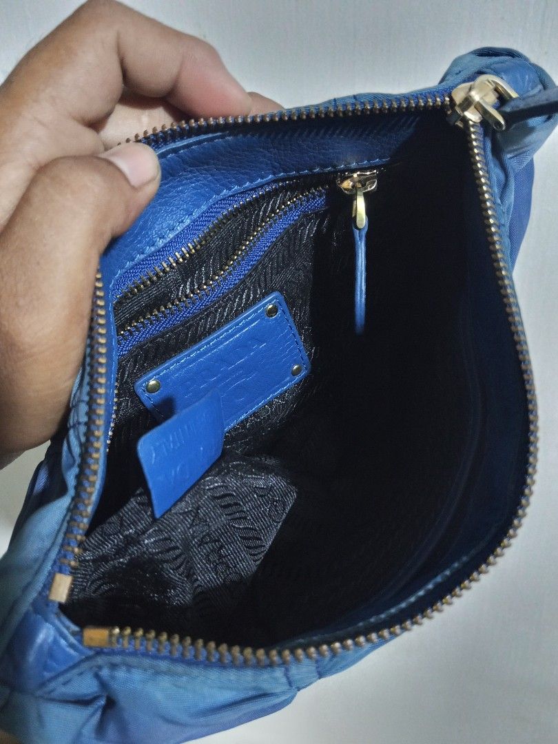 Prada Blue Nylon Ruched Clutch Pouch (Category: Purses & Pouches) located in Glan. Submitted by cpaharodde48008 (Listing ID 1469503303, Image 3). Description: - Authentic Prada pouch in a stylish blue ruched nylon - Elegant gold-tone hardware and secure zipper closure - Signature Prada logo-patterned fabric interior lining - Includes interior leather logo plaque and authenticity tag - Compact and versatile, perfect as a catch-all or a chic clutch