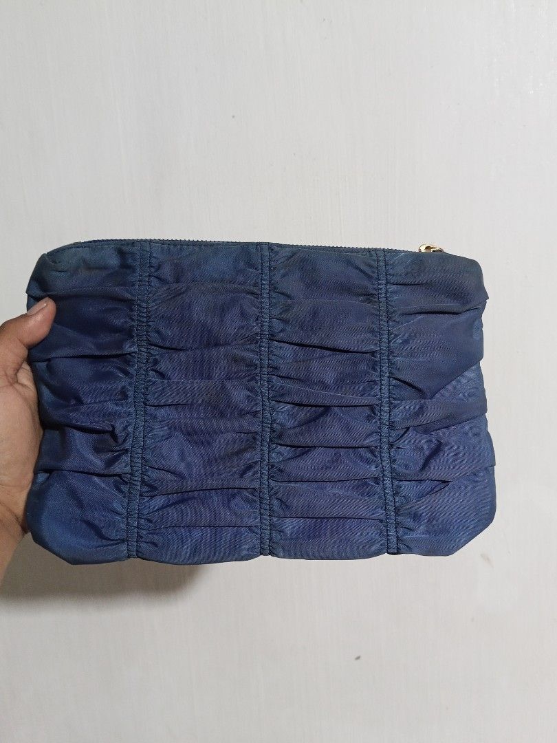 Prada Blue Nylon Ruched Clutch Pouch (Category: Purses & Pouches) located in Glan. Submitted by cpaharodde48008 (Listing ID 1469503303, Image 2). Description: - Authentic Prada pouch in a stylish blue ruched nylon - Elegant gold-tone hardware and secure zipper closure - Signature Prada logo-patterned fabric interior lining - Includes interior leather logo plaque and authenticity tag - Compact and versatile, perfect as a catch-all or a chic clutch