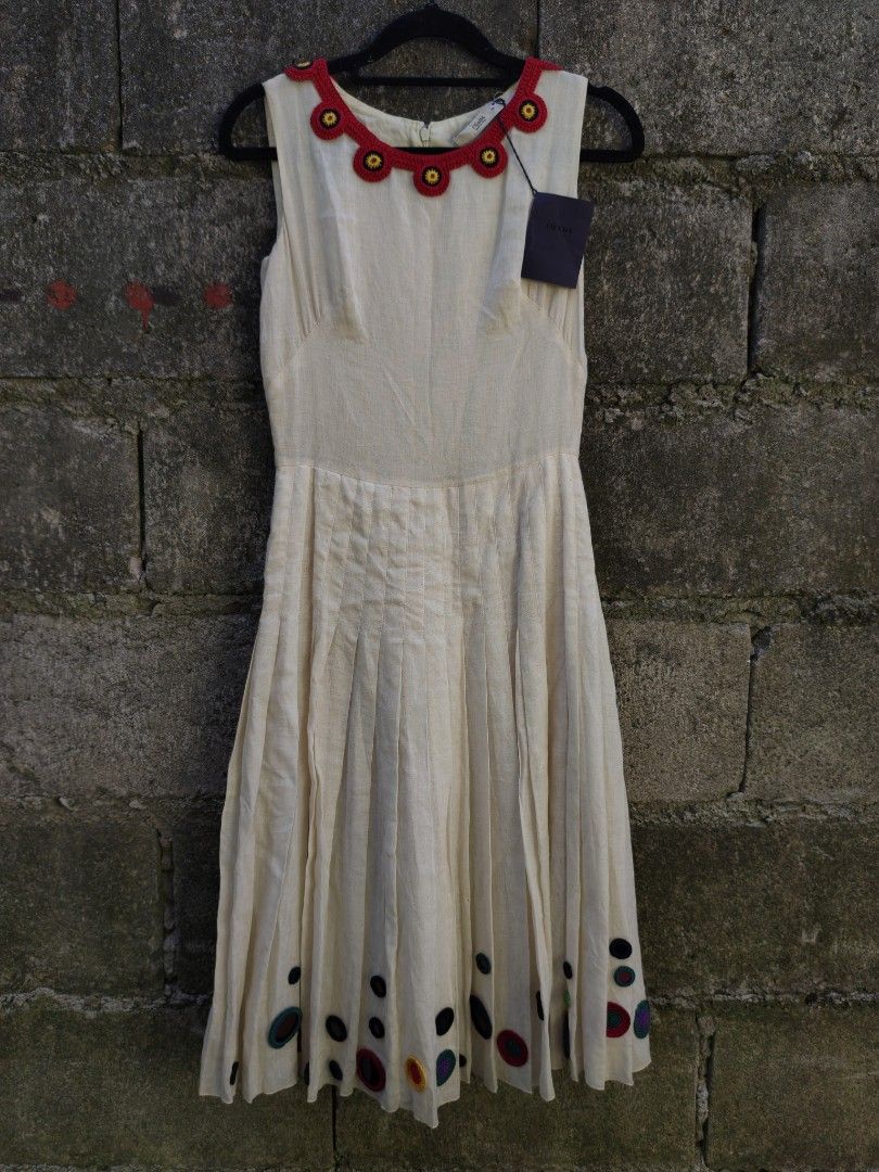 Prada Dress Size 38 (Category: Dresses) located in Bacolod City. Submitted by luciddreams07 (Listing ID 1469458004, Image 1). Description: - Brand: Prada - Style: Sleeveless pleated dress - Color: Cream with red crocheted neckline & floral accents - Size: 38 (Made in Italy) - Condition: Brand new with original tag attached - Details: Pleated skirt with matching round appliques along the bottom hem - Perfect for: Special occasions, dates, or brunc
