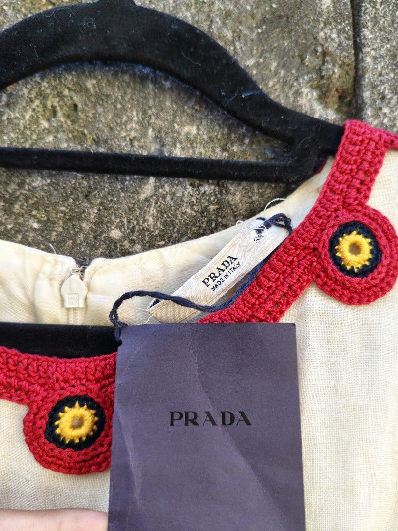 Prada Dress Size 38 (Category: Dresses) located in Bacolod City. Submitted by luciddreams07 (Listing ID 1469458004, Image 2). Description: - Brand: Prada - Style: Sleeveless pleated dress - Color: Cream with red crocheted neckline & floral accents - Size: 38 (Made in Italy) - Condition: Brand new with original tag attached - Details: Pleated skirt with matching round appliques along the bottom hem - Perfect for: Special occasions, dates, or brunc