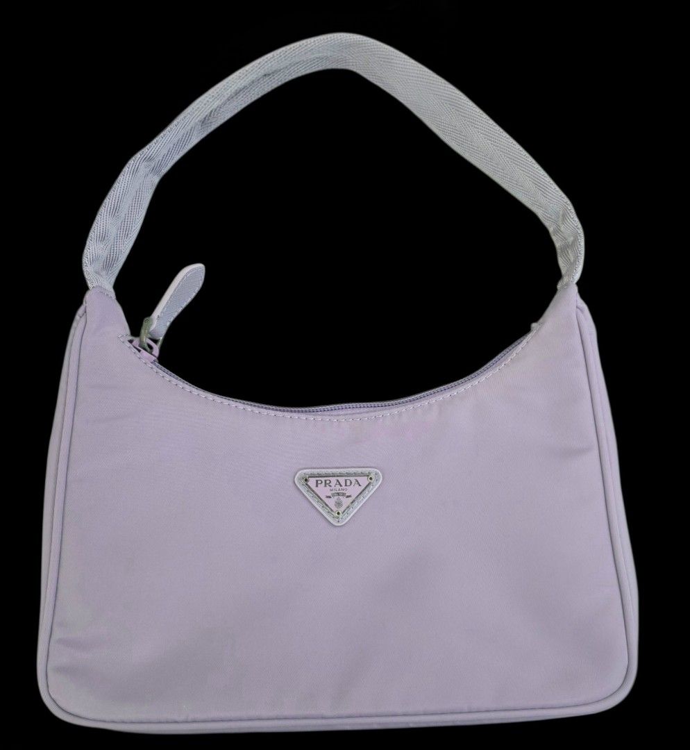 Prada Nylon Mini Bag Lavender (Category: Luxury Bags & Wallets) located in Manila. Submitted by brandedshoppe_mnl (Listing ID 1469523201, Image 1). Description: - Brand: Authentic VintagePrada - Material: Durable nylon in a gorgeous lavender shade - Hardware: Silver-tone with classic front triangular logo plaque - Closure: Zip-top secure closure - Interior: Branded jacquard lining with a convenient inside pocket - Strap: Short shoulder strap feat