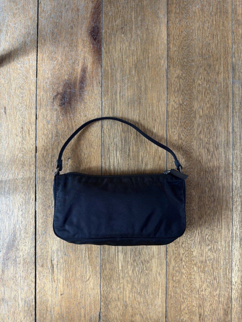 PRADA Nylon Pochette (Category: Luxury Bags & Wallets) located in Davao. Submitted by _iconculture (Listing ID 1469523698, Image 3). Description: AVAILABLE • PRADA Tessuto Nylon Pochette ★ A true classic that never goes out of style. Condition: 9.8/10 — Almost mint condition! Has minor dirt marks on the body that may be removed with proper cleaning. Clean interior. Small but mighty, she can fit your iPhone Pro Max, wallet, and other daily essenti