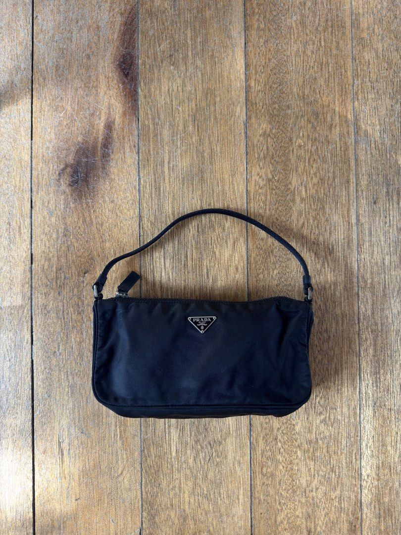 PRADA Nylon Pochette (Category: Luxury Bags & Wallets) located in Davao. Submitted by _iconculture (Listing ID 1469523698, Image 1). Description: AVAILABLE • PRADA Tessuto Nylon Pochette ★ A true classic that never goes out of style. Condition: 9.8/10 — Almost mint condition! Has minor dirt marks on the body that may be removed with proper cleaning. Clean interior. Small but mighty, she can fit your iPhone Pro Max, wallet, and other daily essenti