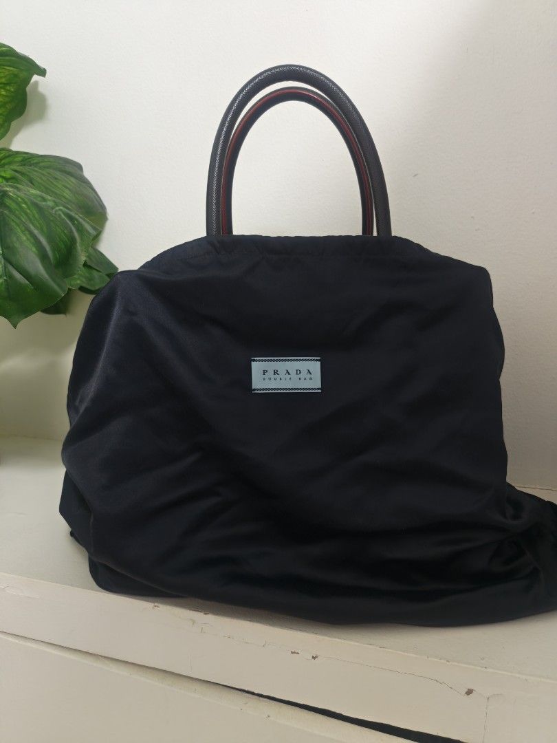 Prada Saffiano Double Bag Black and Red (Category: Luxury Bags & Wallets) located in Caloocan City. Submitted by champyb0y_359 (Listing ID 1469545103, Image 1). Description: - Authentic Prada Saffiano Double Bag - Color: Black exterior with bold red interior lining - Hardware: Premium gold-tone hardware with signature triangular metal logo - Features: Double top handles, convenient center flap compartment, and matching luggage tag with gold lette