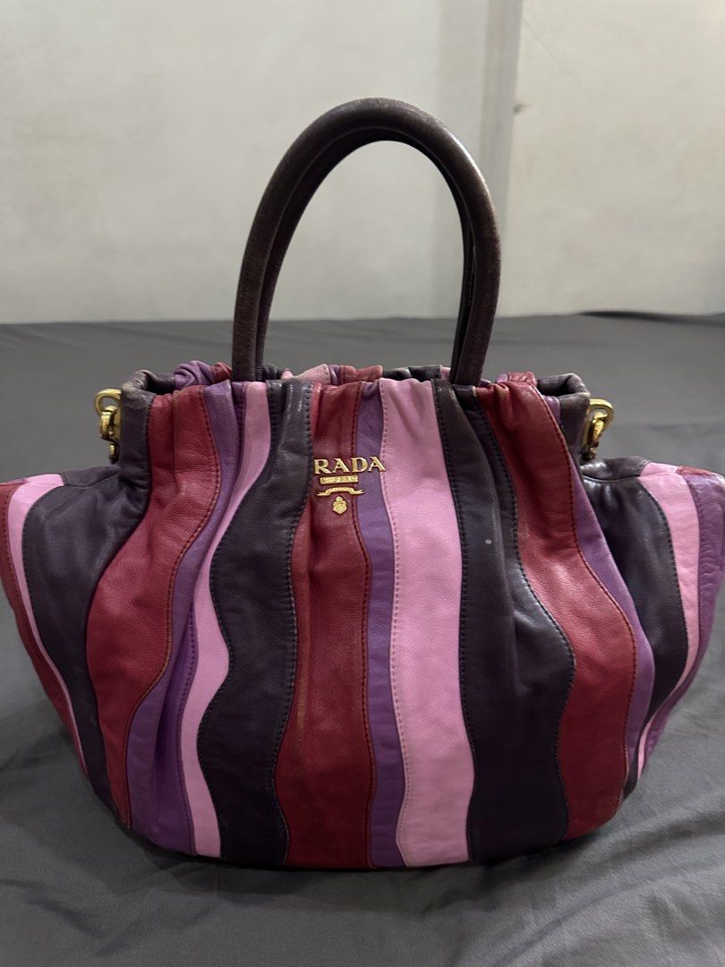 Prada Striped Leather Handbag with Shoulder Strap (Category: Luxury Bags & Wallets) located in Caloocan City. Submitted by mariecarol62420 (Listing ID 1469475649, Image 1). Description: - Brand: Prada - Design: Multicolored vertical stripes in pink, burgundy, and dark purple - Hardware: Gold-tone with centered Prada Milano logo plaque - Handles/Strap: Dual top carry handles plus an adjustable, detachable leather shoulder strap - Interior: Roomy c