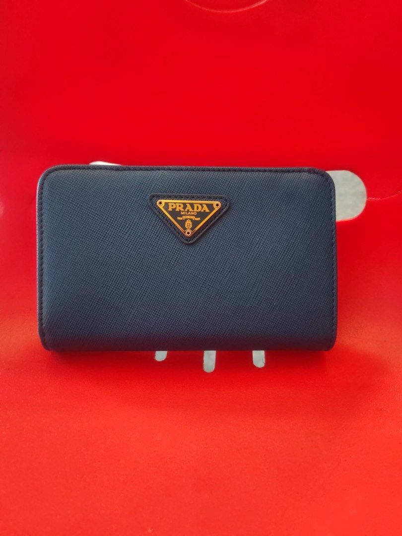 Pre loved Saffiano Leather Blue Wallet (Category: Luxury Bags & Wallets) located in Manila. Submitted by cosmicbear-ead33b (Listing ID 1469403145, Image 1). Description: - Authentic Prada wallet in sophisticated dark blue Saffiano leather - Iconic gold-toned metal logo plaque on the front - Secure snap button closure - Multiple card slots inside for easy organization - Compact size that fits effortlessly into any handbag - Immaculate stitching an