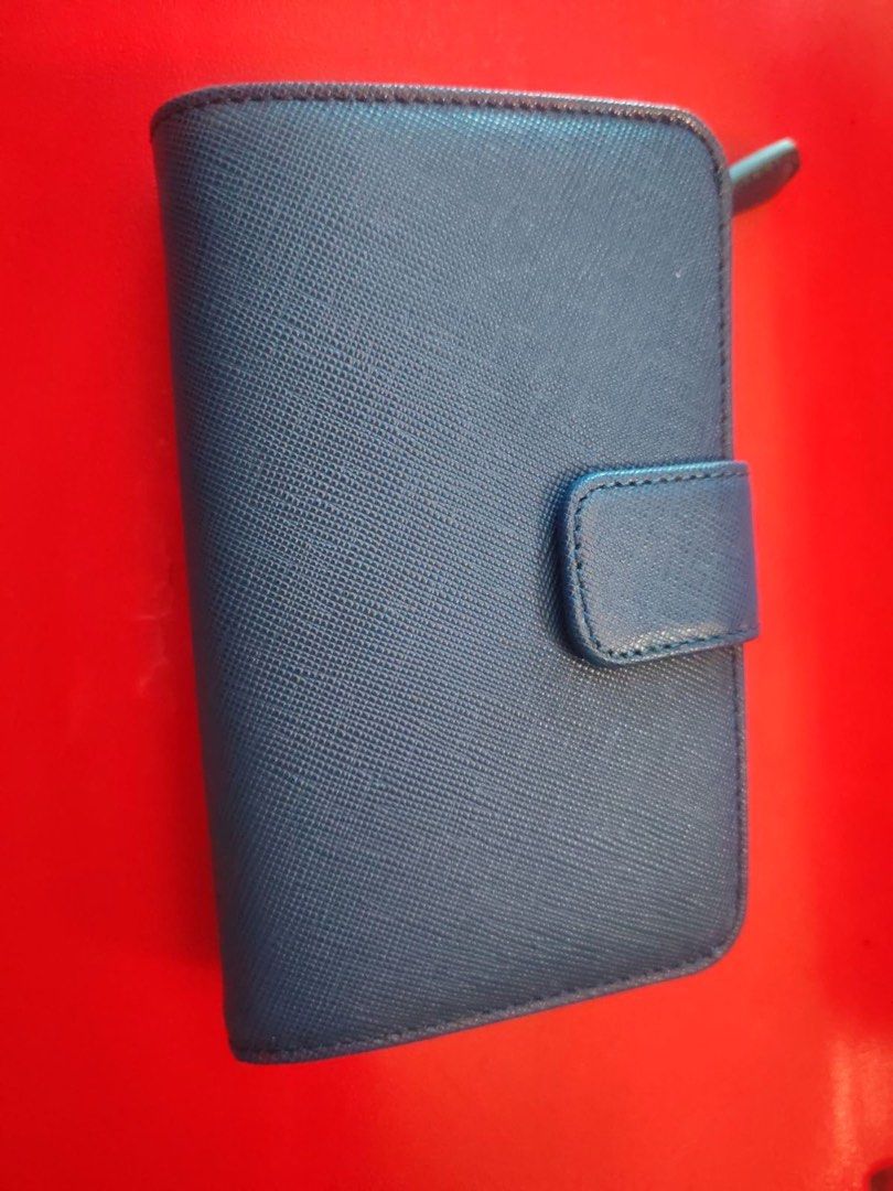 Pre loved Saffiano Leather Blue Wallet (Category: Luxury Bags & Wallets) located in Manila. Submitted by cosmicbear-ead33b (Listing ID 1469403145, Image 2). Description: - Authentic Prada wallet in sophisticated dark blue Saffiano leather - Iconic gold-toned metal logo plaque on the front - Secure snap button closure - Multiple card slots inside for easy organization - Compact size that fits effortlessly into any handbag - Immaculate stitching an