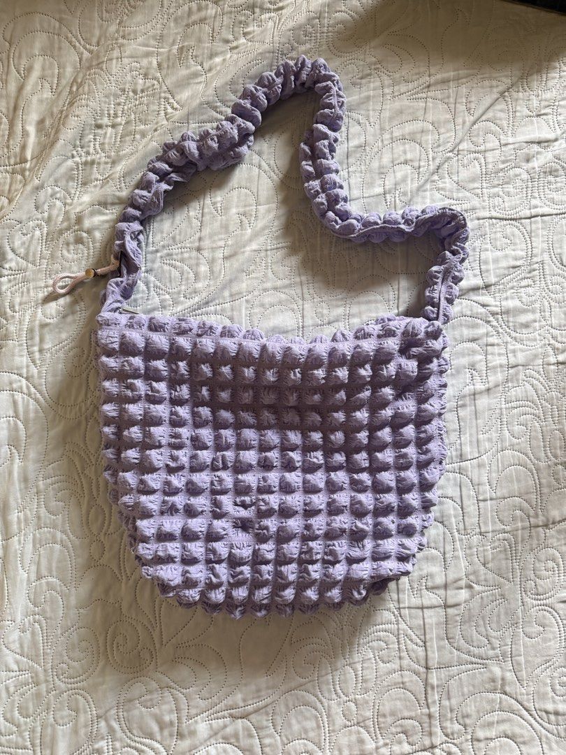 Purple textured bubble shoulder bag hobo style (Category: Shoulder Bags) located in Batangas. Submitted by ystyledx (Listing ID 1469568231, Image 2). Description: - Color: Light purple - Design: Unique textured bubble pattern with soft crinkled fabric - Style: Roomy everyday hobo shoulder bag with a matching strap - Closure: Zipper top with a cute side pull string detail - Material: Very stretchy and flexible - Condition: Clean interior lining.