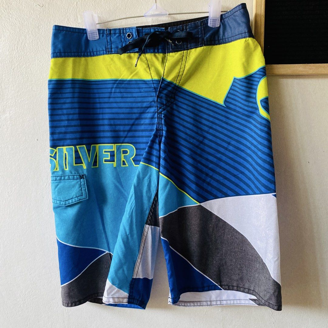 Quiksilver Men's Board Shorts (Category: Swim Trunks & Board Shorts) located in Caloocan City. Submitted by lovemyclothes21 (Listing ID 1469406618, Image 2). Description: - Brand: Quiksilver - Size: 28 - Colorway: Blue, neon yellow, white, and grey - Design: Geometric graphic print with striped details and side branding - Features: Adjustable drawstring waist, small utility pocket on the right thigh, and logo patch on the back - Condition/Use: Gr