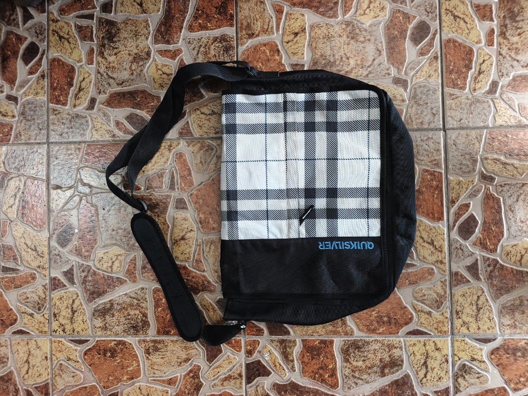 Quiksilver Plaid Messenger Bag Black White (Category: Sling Bags) located in Bayombong. Submitted by onlygoodfinds. (Listing ID 1469408883, Image 1). Description: - Authentic Quiksilver messenger bag - Stylish plaid flap with durable black lower panel and blue embroidered logo - Spacious main compartment with black fabric lining - Extra interior and exterior pockets for better organization - Adjustable shoulder strap with comfortable padded grip 