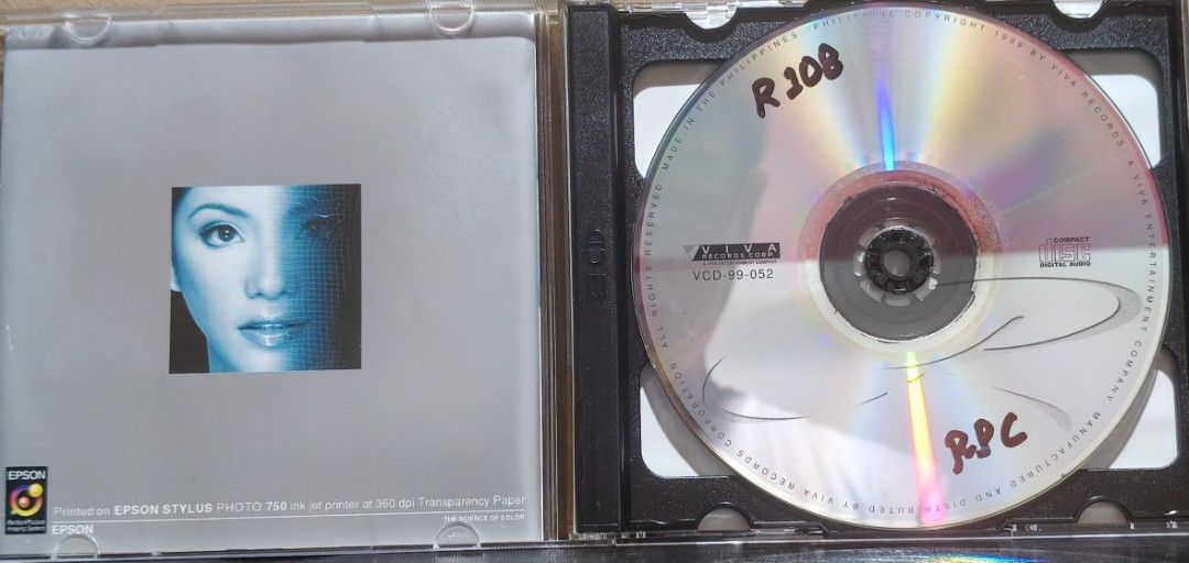 R2K CD Album Viva Records (Category: CDs & DVDs) located in Manila. Submitted by ruelcabrer77078 (Listing ID 1469555625, Image 2). Description: Regine Velasquez R2K album released by Viva Records in 1999. Includes jewel case, booklet insert printed on Epson transparency paper, and compact disc. Disc has handwritten markings in marker. Case has minor scratches from regular storage. Playable audio disc..