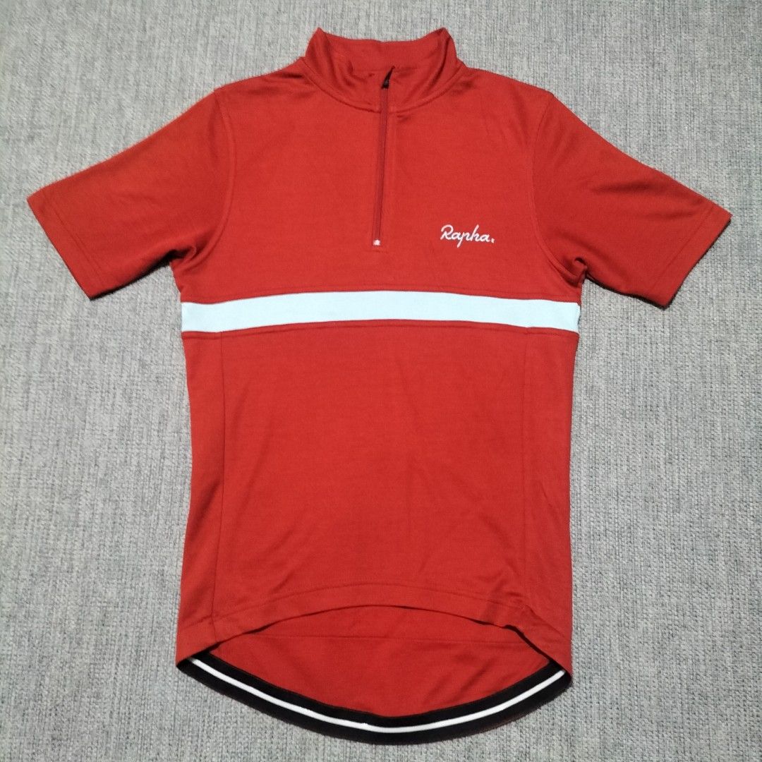 Rapha Short Sleeve Cycling Jersey Red White (Category: Activewear) located in Taytay. Submitted by calmtree-6248 (Listing ID 1469536803, Image 1). Description: - Brand: Rapha - Color: Bright red with light blue chest stripe - Design: Short sleeve, half zip neck closure, and high collar - Fit/Features: Dropped hem with black and white grip band at the back - Material: Lightweight, breathable fabric ideal for road cycling - Condition: Clean bright 
