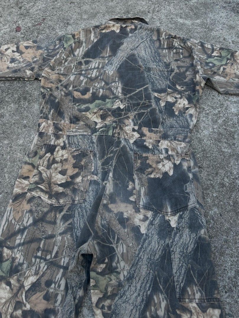 RealTree Camo BreakUp Pattern All In One Jumpsuit (Category: Jumpsuits) located in Makati City. Submitted by chichi_buka888 (Listing ID 1469502789, Image 3). Description: - Authentic RealTree BreakUp camouflage pattern with realistic tree bark and leaf print - All-in-one jumpsuit design with long sleeves and a collared neckline - Multiple functional pockets on the chest and back for easy storage - Durable, heavy-duty fabric built for outdoor work