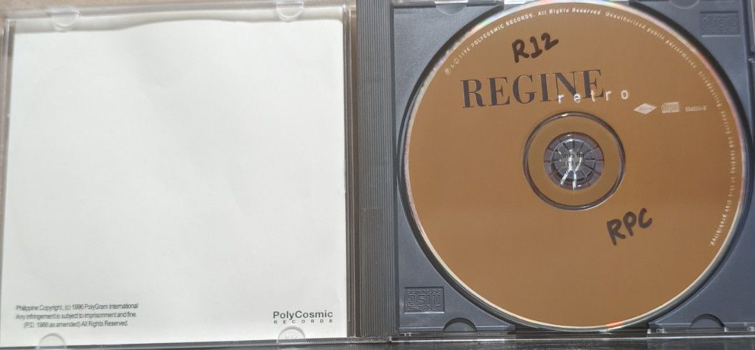 Regine Retro CD Album PolyCosmic Records (Category: CDs & DVDs) located in Manila. Submitted by ruelcabrer77078 (Listing ID 1469555544, Image 2). Description: - Artist & Album: Regine - Retro - Release Year: 1996 - Record Label: PolyCosmic Records - Packaging: Standard jewel case with front cover artwork and back insert sleeve included - Condition Note: Disc has handwritten markings in permanent marker on the surface - Ideal for OPM collectors an