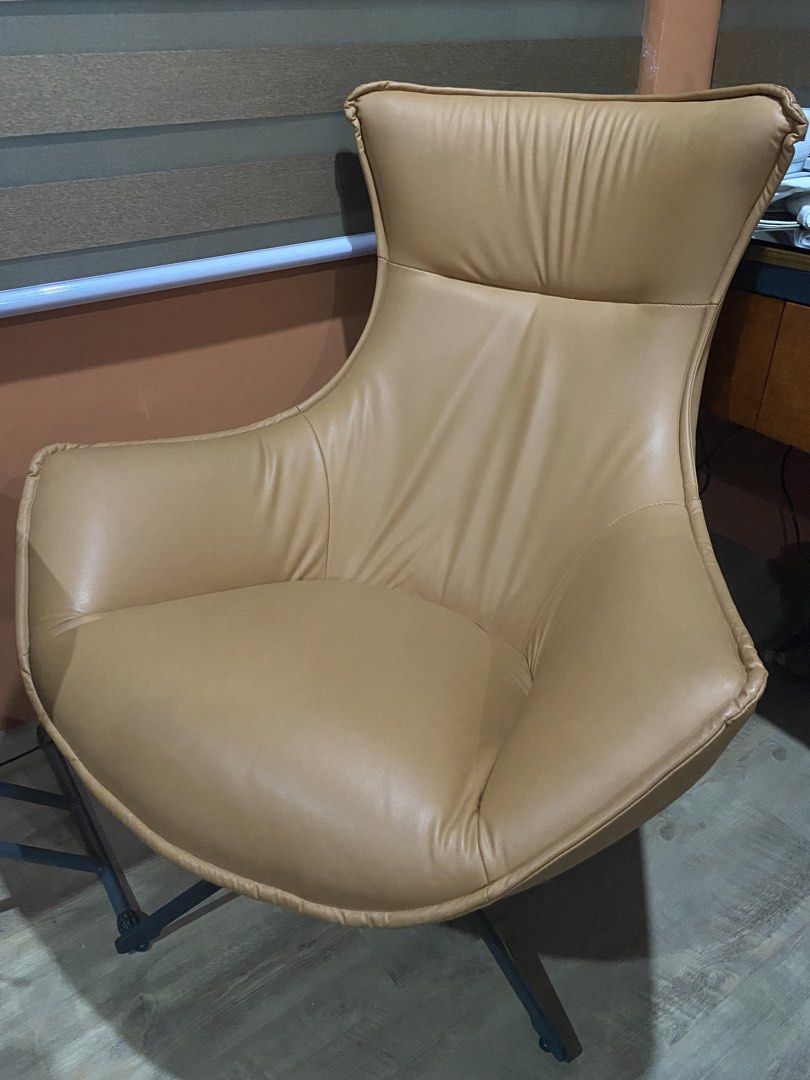 Relaxing Accent Chair (Category: Chairs) located in Kawit. Submitted by ahaleco (Listing ID 1469513098, Image 2). Description: This sleek swivel accent chair brings a bold, mid-century modern vibe to any room. Its standout feature is the flowing, organic silhouette resembling a stylized snail shell or egg that creates a deep, cradling bucket seat for ultimate lounging. Orange Brown Color.