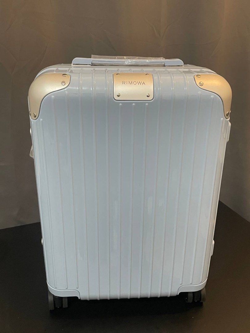 Rimowa light blue hardshell suitcase with gold hardware (Category: Luggage) located in Manila. Submitted by thelux2026 (Listing ID 1469567922, Image 1). Description: - Authentic Rimowa hardshell suitcase in a chic light blue color - Premium gold-tone metal corners and front brand plaque - Secure dual combination locks for safe traveling - Clean ribbed exterior design with sturdy side hinges - Smooth multi-wheel setup for effortless mobility - Sid