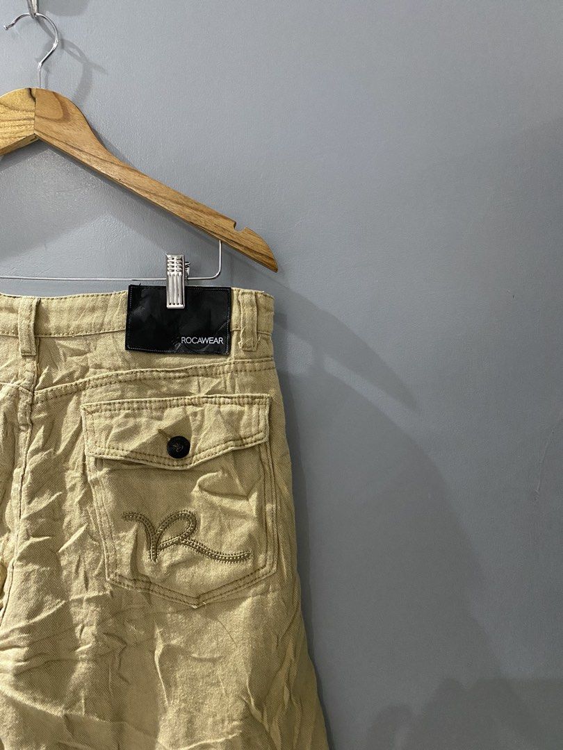 Rocawear Khaki Cargo Shorts (Category: Shorts) located in Bangued. Submitted by koroysthrifts (Listing ID 1469519088, Image 1). Description: 34x23x11.5 Rocawear khaki cargo shorts in a tan shade. Heavy twill fabric construction with multiple utility pockets on the back and sides. Embroidered logo detailing on the back pocket flap and front coin pocket. Button fly closure and branded waistband tag. Solid streetwear staple..