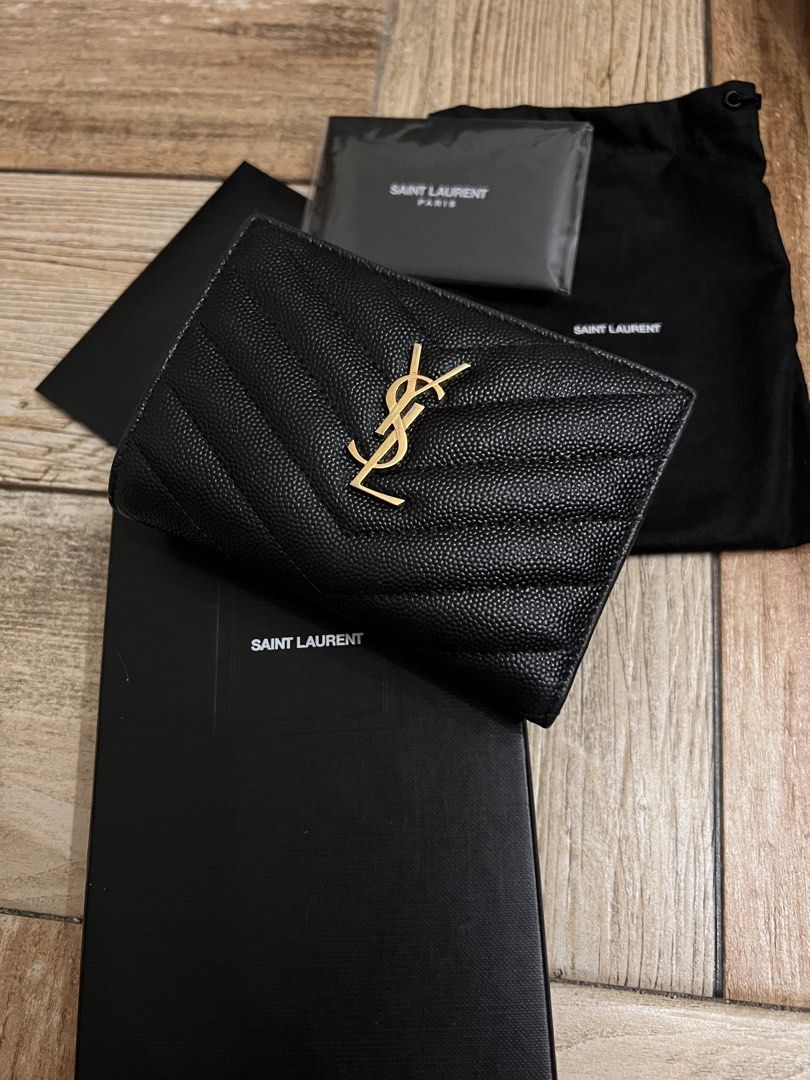 Saint Laurent YSL Monogram Compact Bi-fold Wallet Black (Category: Luxury Bags & Wallets) located in Malabon City. Submitted by levineabby (Listing ID 1467398426, Image 1). Description: - Brand: Saint Laurent (YSL) - Material: Black quilted leather with gold hardware - Hardware: Gold interlocking YSL logo and interior gold stamp - Closure: Secure snap button - Interior: Card slots and a convenient coin compartment - Size: Compact, fits easily int