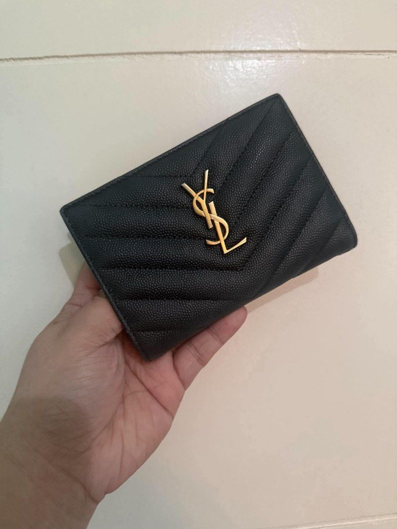 Saint Laurent YSL Monogram Quilted Compact Wallet Black Gold (Category: Luxury Bags & Wallets) located in Quezon City. Submitted by hellopatchi (Listing ID 1469435580, Image 1). Description: - Brand: Saint Laurent - Material: Black grained leather with chevron quilting - Hardware: Gold-tone - Logo: Classic interlocking YSL front logo - Closure: Snap button - Interior: Multiple card slots and compartments - Size: Compact, fits easily in small hand
