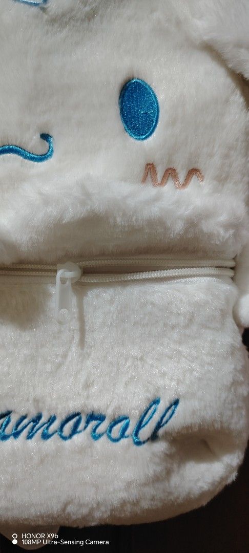 Sanrio Cinnamoroll Fluffy Plush Backpack White Blue Bow (Category: Plushies & Soft Toys) located in Manila. Submitted by justybelieve2026 (Listing ID 1469452108, Image 2). Description: - Super soft white plush Cinnamoroll backpack - Features cute blue embroidered eyes, mouth, and name on the front pocket - Adorned with a sweet light blue gingham bow on top - Adjustable white straps with secure black buckles - Clean white inner lining with a relia
