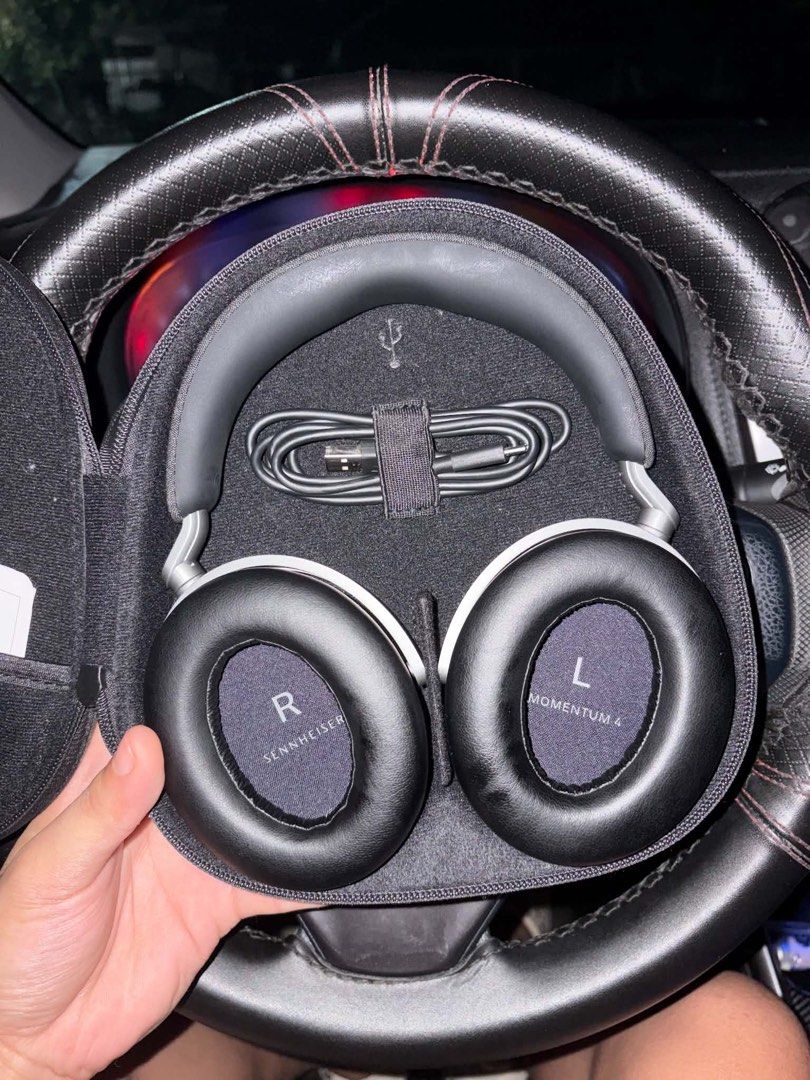 Sennheiser Momentum 4 Wireless Headphones (Category: Headphones & Headsets) located in Sarrat. Submitted by juswah_ (Listing ID 1469396375, Image 3). Description: - Brand: Sennheiser Momentum 4 Wireless - Color: Black - Inclusion 1: Clean fabric hard carry case with centered silver logo - Inclusion 2: Protective case pockets contain audio cable, USB-C charging cable, flight adapter, and manual.