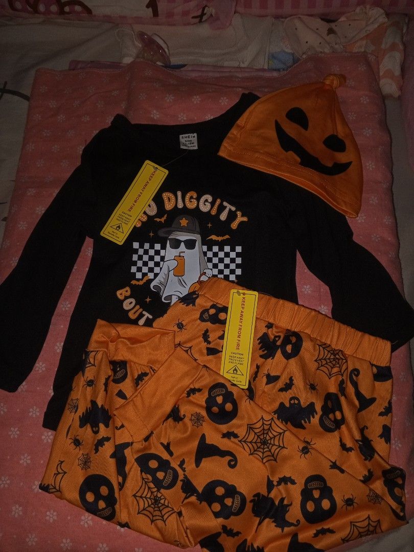 SHEIN Halloween Ghost Romper Pants and Pumpkin Beanie Set (Category: Babies & Kids Fashion) located in Magalang. Submitted by zeiansoria64090 (Listing ID 1469414622, Image 2). Description: - Brand: SHEIN - Condition: Brand new with tags (BNWT) - Size: 12-18 months - Set includes: Black long-sleeve bodysuit ('No Diggity Bout to Bag It Up' ghost graphic), orange trousers (skulls, witch hats, bats, spiderwebs), and a matching pumpkin beanie with jac