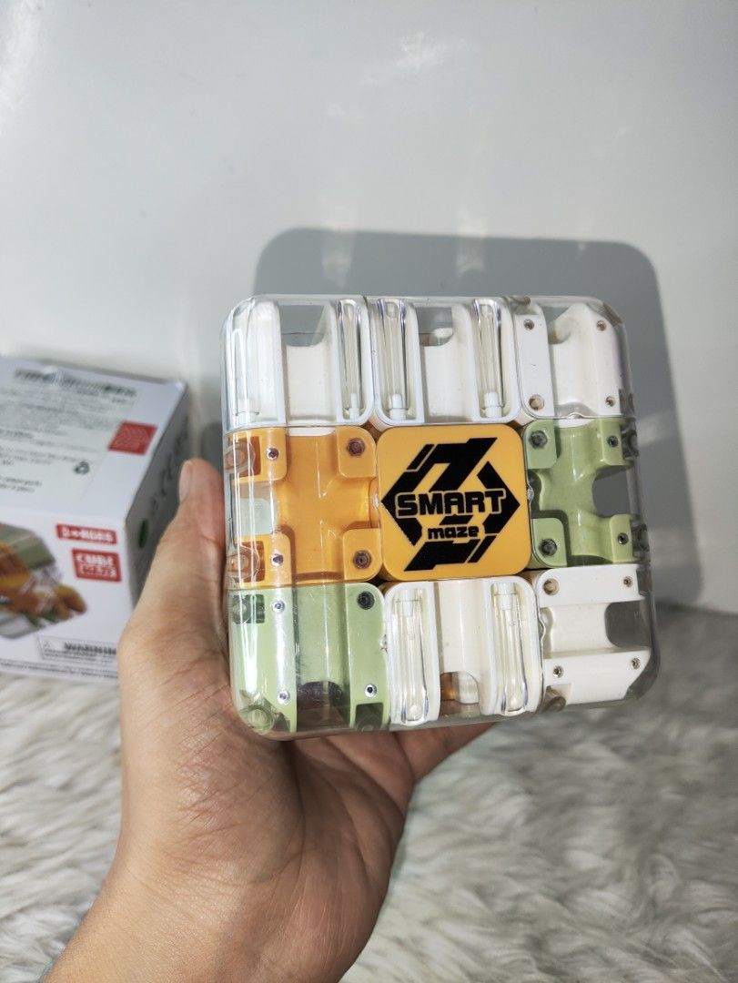 Smart Maze 3D Puzzle Cube Toy (Category: Board Games & Puzzles) located in Cavite. Submitted by tinetaclesss (Listing ID 1469498865, Image 3). Description: - Interactive smart maze puzzle cube in a sleek clear plastic housing - Features multi-colored rotating sections in white, olive green, and orange - Keeps hands busy and sharpens problem-solving skills - Suitable for kids and adults, ages 3 and up - Comes complete with its original box - great