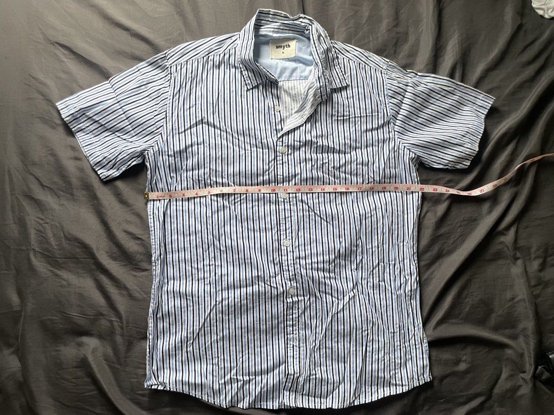 Smyth Blue Striped Short Sleeve (Category: Tshirts & Polo Shirts ) located in Mandaluyong City. Submitted by _javiii (Listing ID 1469415914, Image 2). Description: - Brand/Model: Smyth Short Sleeve Button-Down Shirt - Colorway: Blue, white, and black vertical stripes - Size: Fits L-XL - Measurements (Flat Lay): Length approx. 28 inches, Chest width approx. 25 inches - Material: Lightweight cotton - Style: Classic collar, ideal for casual everyday