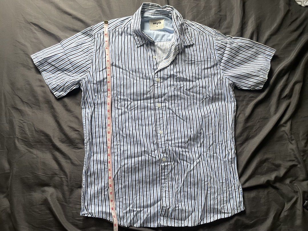Smyth Blue Striped Short Sleeve (Category: Tshirts & Polo Shirts ) located in Mandaluyong City. Submitted by _javiii (Listing ID 1469415914, Image 1). Description: - Brand/Model: Smyth Short Sleeve Button-Down Shirt - Colorway: Blue, white, and black vertical stripes - Size: Fits L-XL - Measurements (Flat Lay): Length approx. 28 inches, Chest width approx. 25 inches - Material: Lightweight cotton - Style: Classic collar, ideal for casual everyday