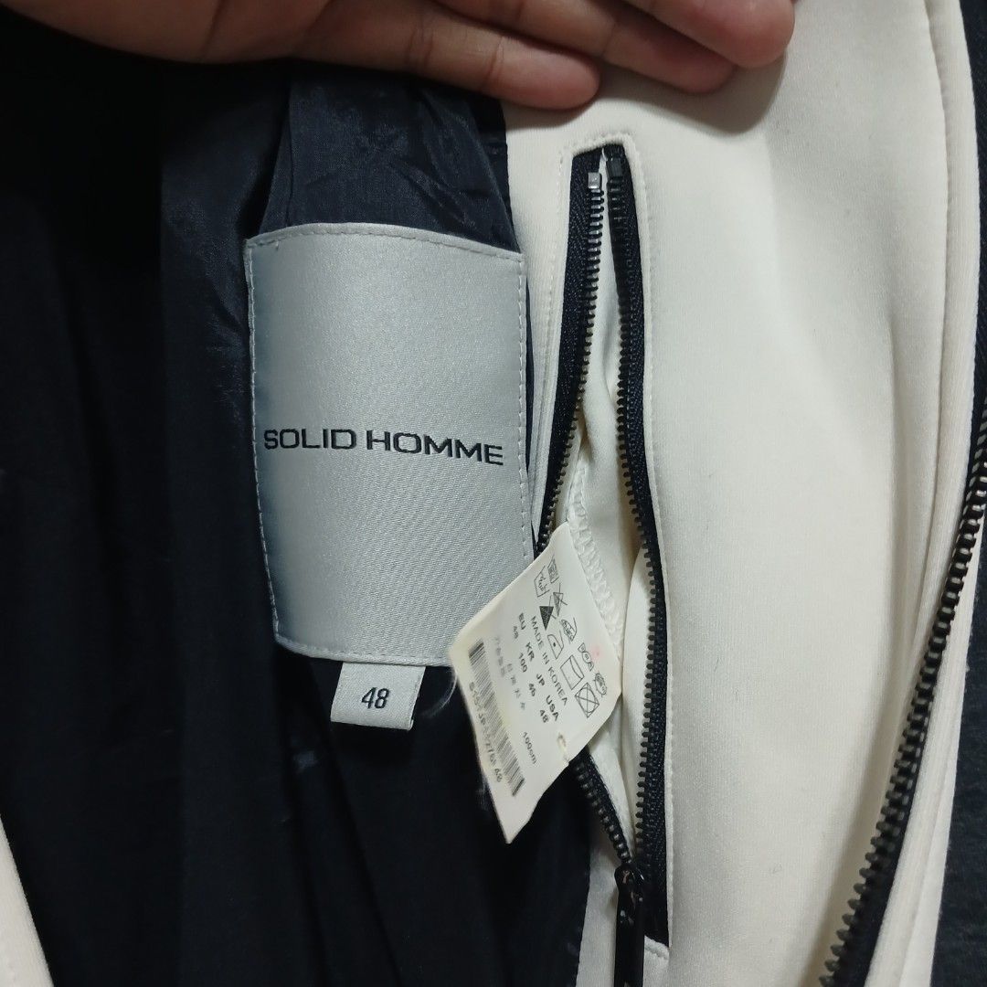 Solid Homme Bomber Jacket Size 48 (Category: Coats, Jackets and Outerwear) located in Manila. Submitted by joefrey12 (Listing ID 1469495117, Image 3). Description: - Brand: Solid Homme - Style: Colorblock bomber jacket (White, Black, Dark Grey) - Size: 48 (Made in Korea) 21x27 - Features: Zip closure, two side zipper pockets, ribbed collar, cuffs, and hem - Material: Wool blend (Note: fabric is prone to pilling as per care label) - Condition: Exc