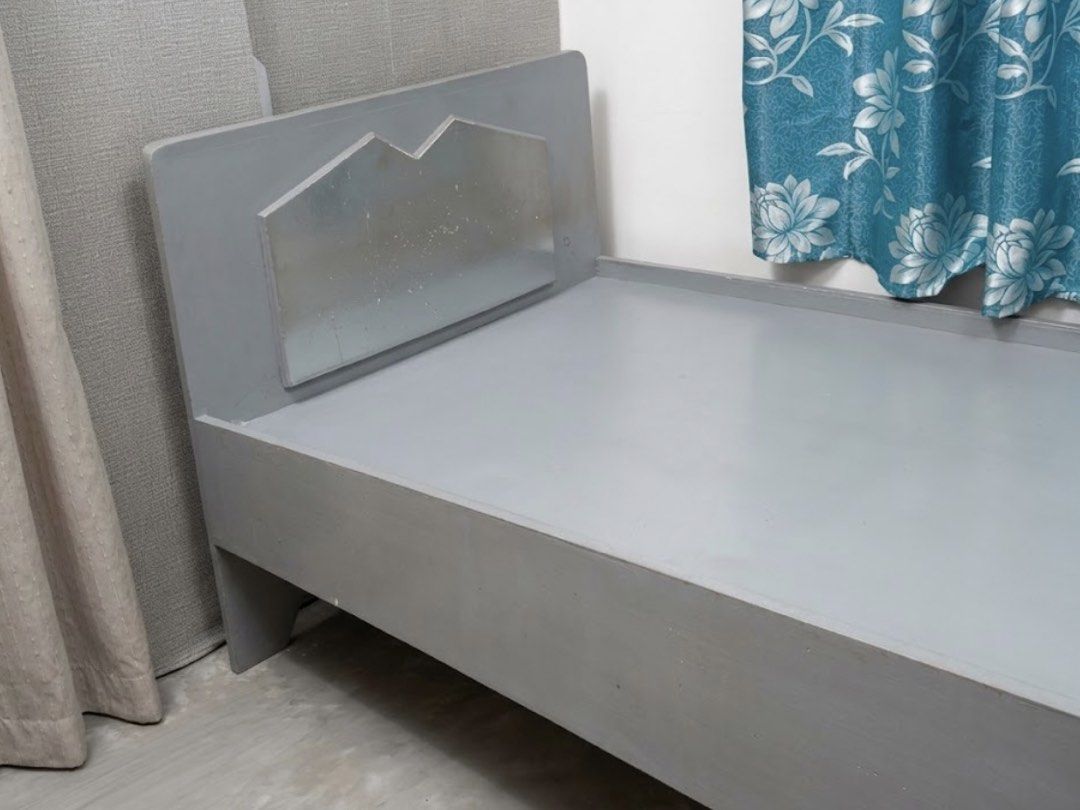Solid Wood Single Bed Frame Grey (Category: Bed Frames & Mattresses) located in Taguig. Submitted by ccitemsss (Listing ID 1469535315, Image 2). Description: Type: Grey wooden single bed frame Design: Modern geometric headboard with a sturdy panel platform base Size: Fits a standard single mattress Condition: Pre-loved with minor signs of usage, including slight peeling/chipping of the paint in some areas. Note: The bed frame cannot be disassembl