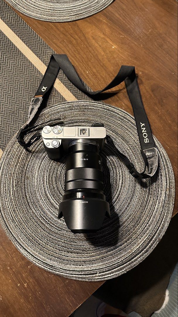 Sony A6000 Mirrorless Camera with Lens (Category: Cameras) located in Cavite. Submitted by gelocalvaran (Listing ID 1469510537, Image 2). Description: - Camera Model: Sony a6000 mirrorless camera - Lens: Sony 18-105mm f/4 G lens included - Features: Tilting LCD screen, built-in electronic viewfinder, and fully functional pop-up flash - Inclusions: Branded neck strap and lens hood - Condition: Minor cosmetic wear around strap lugs and body edges d