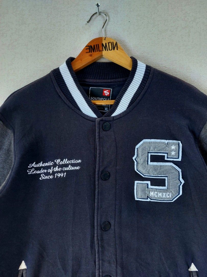Southpole 2000's Varsity Fleece Jacket (Category: Coats, Jackets and Outerwear) located in Palayan City. Submitted by akhai420 (Listing ID 1469423972, Image 2). Description: - Brand: Southpole - Style: Varsity jacket - Color: Black and dark grey - Size: XL on tag / best fit Large - Details: Large 'S' chest patch with stars and MCMXCI text - Embroidery: 'Authentic Collection Leader of the culture Since 1991' - Features: Button-up front, slip pocke
