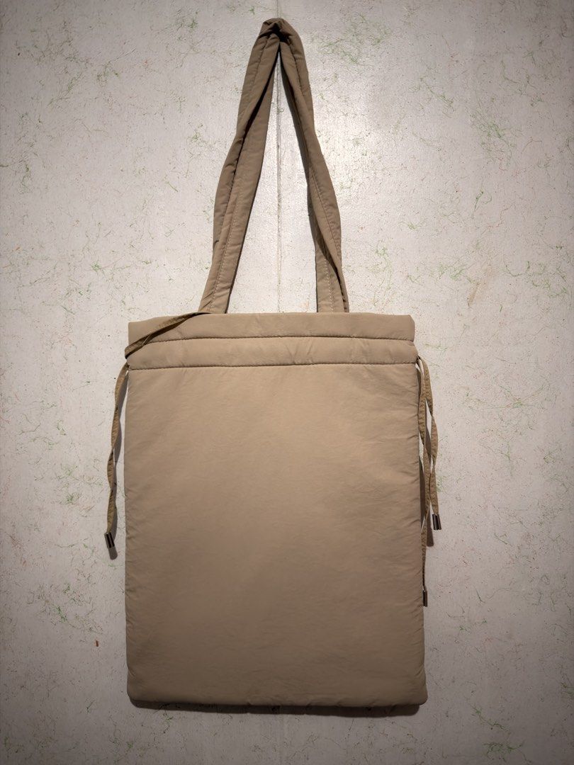 Straightforward Sufla Tote (Category: Tote Bags) located in San Pablo. Submitted by yortle (Listing ID 1469423941, Image 2). Description: - Brand: Straightforward - Color: Khaki - Material: Puffer nylon (lightweight & spacious) - Features: Two front slip pockets and secure drawstring top closure - Straps: Two long shoulder straps for comfortable carry - Style: Minimalist daily carryall, perfect for everyday use.