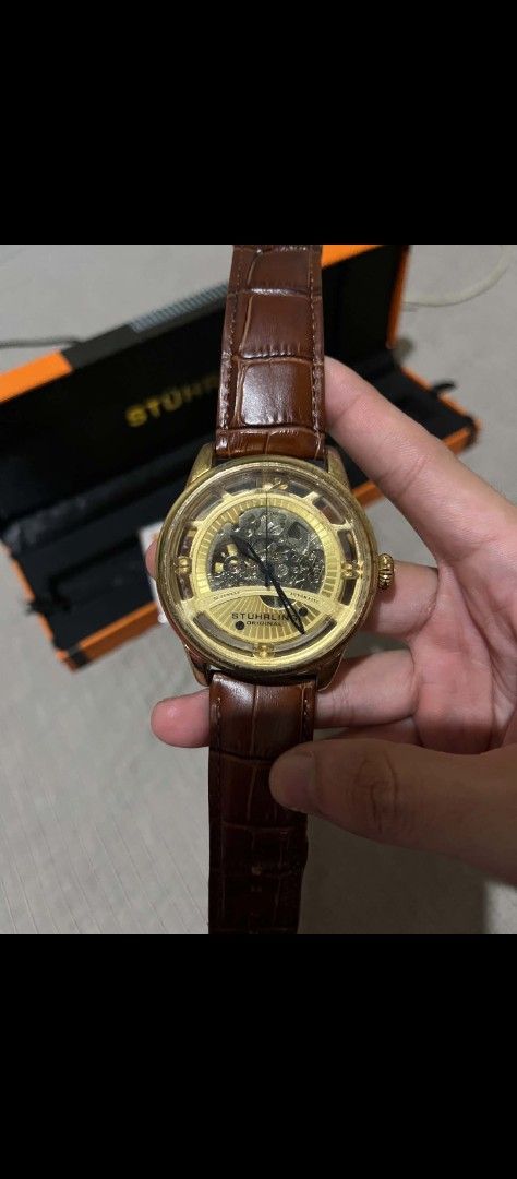 Stuhrling Dauphine 3974 Skeleton Watch (Category: Men's Watches) located in Lucena. Submitted by erniera28 (Listing ID 1469447738, Image 2). Description: - Brand: Stuhrling - Model: Dauphine 3974 - Movement: Automatic skeleton - Case Size: 48mm - Case Color: Gold-tone - Strap: Brown leather - Special Features: Skeleton dial, exhibition case back - Inclusions: Original orange and black box.