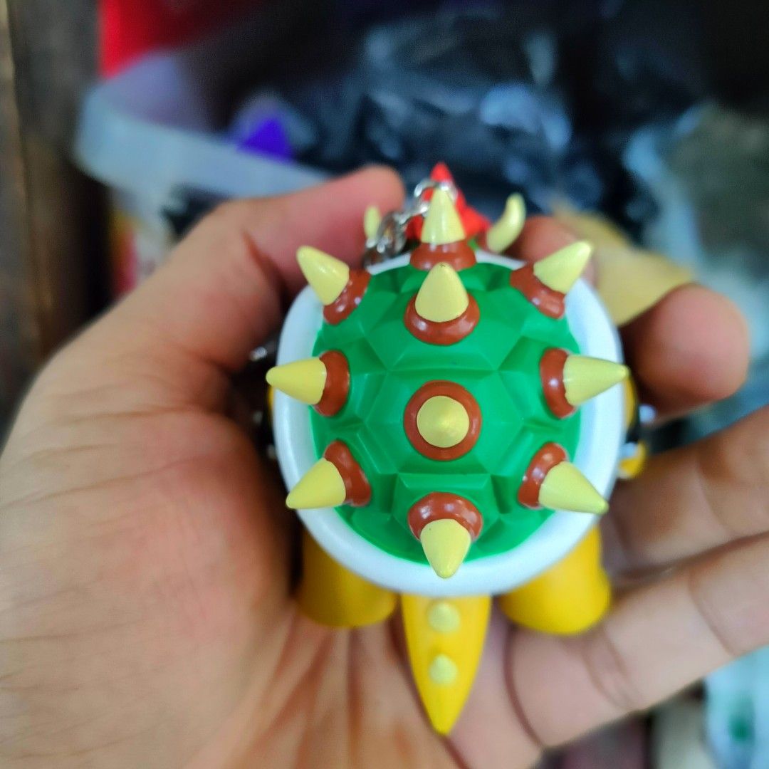 Super Nintendo World Bowser Keychain Universal Studios Japan (Category: Character Goods) located in Plaridel. Submitted by klayskolektibols (Listing ID 1469428676, Image 3). Description: - Official Universal Studios Japan Super Nintendo World merchandise - Bowser character figurine made of solid PVC - Features vibrant paint details on his shell, horns, and spikes - Heavy-duty metal ring with official branding stamp on the back - Great as a keycha