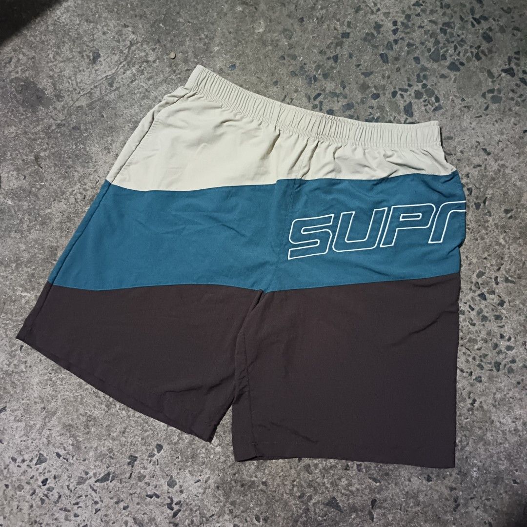 Supreme Colorblocked Nylon Shorts Size Medium (Category: Shorts) located in Caloocan City. Submitted by gemfinder669 (Listing ID 1469533160, Image 1). Description: - Brand: Supreme - Style: Three-tone color block nylon shorts (Beige, Teal, Brown) - Size: Medium (tags attached) - Features: Elastic waistband with interior drawcord, lightweight material - Branding: Large diagonal Supreme logo printed on the teal panel - Origin: Made in China - Measu