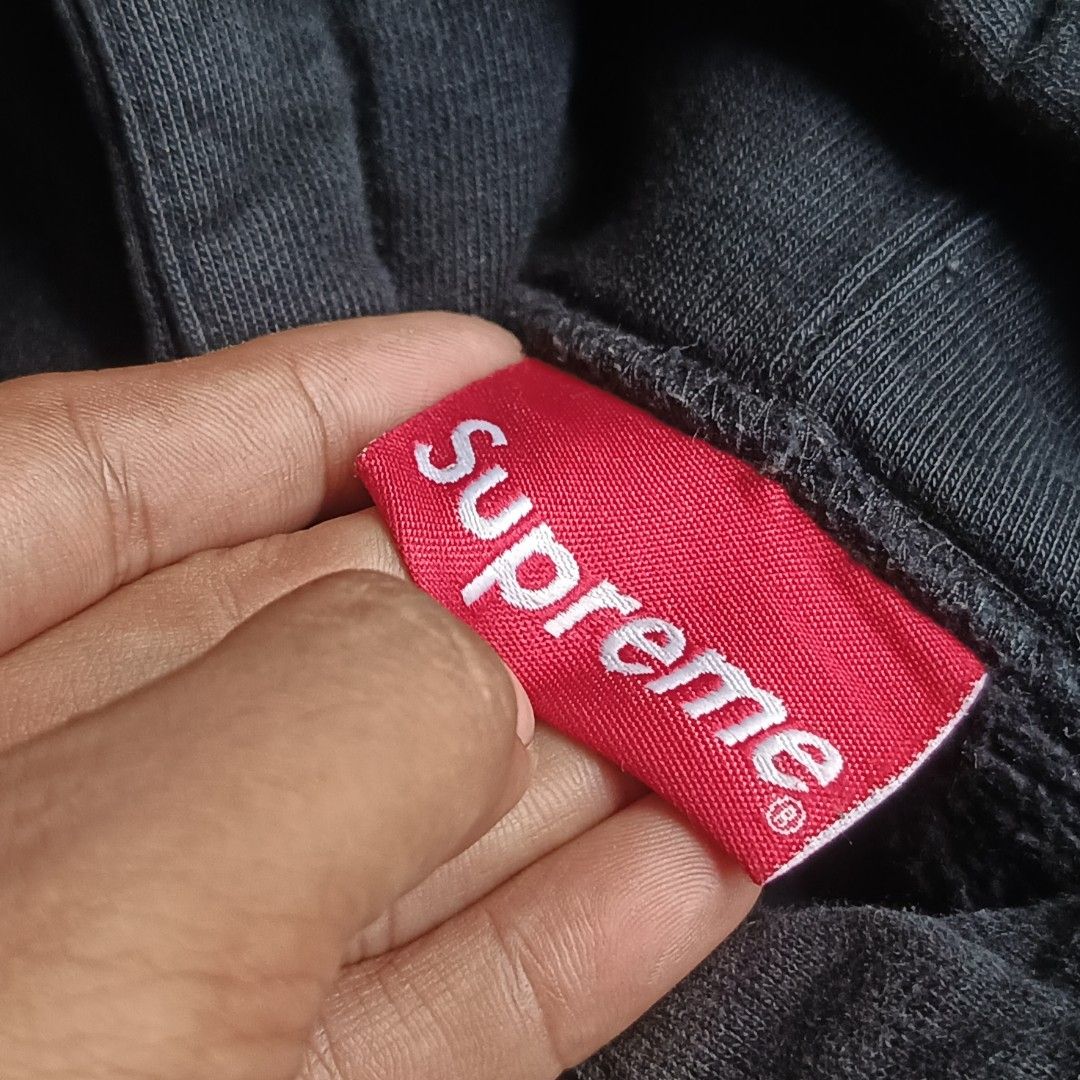 Supreme Diagonal Stripe Hooded Sweatshirt Black Large (Category: Hoodies) located in Caloocan City. Submitted by gemfinder669 (Listing ID 1469524829, Image 2). Description: Black Authentic Supreme hoodie with white diagonal contrast stripes and bold stitched logo across the front. Drawstring hood, ribbed cuffs, and hem. Size Large tag attached inside. Interior care label lists 100 percent cotton, machine wash cold, made in China. Fabric shows sli