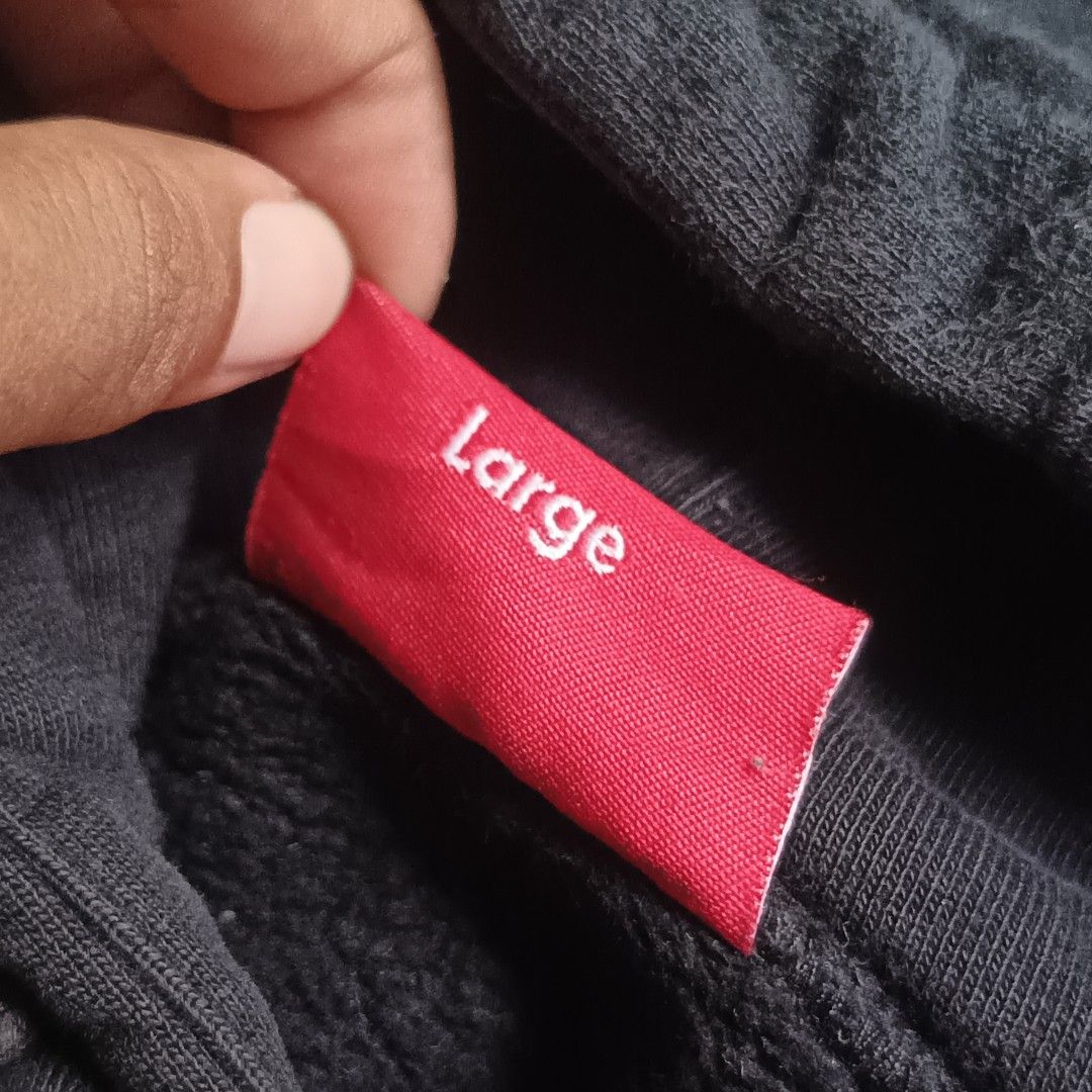 Supreme Diagonal Stripe Hooded Sweatshirt Black Large (Category: Hoodies) located in Caloocan City. Submitted by gemfinder669 (Listing ID 1469524829, Image 3). Description: Black Authentic Supreme hoodie with white diagonal contrast stripes and bold stitched logo across the front. Drawstring hood, ribbed cuffs, and hem. Size Large tag attached inside. Interior care label lists 100 percent cotton, machine wash cold, made in China. Fabric shows sli