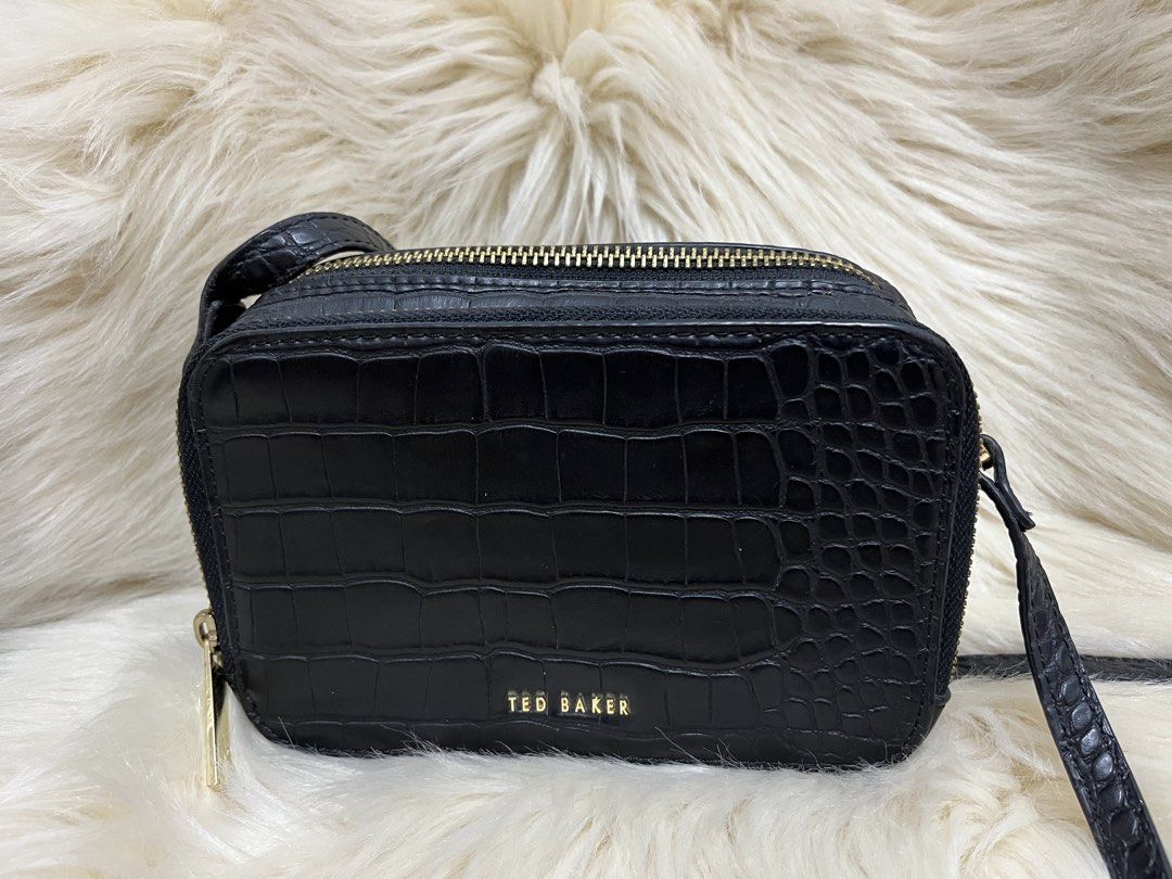 Ted Baker Black Croc Embossed Crossbody Bag (Category: Cross-body Bags) located in Naga. Submitted by ownlineshopp (Listing ID 1469502475, Image 1). Description: - Brand: Ted Baker - Color: Black with chic croc-embossed texture - Hardware: Premium gold-tone details and front logo lettering - Compartments: Secure double zippered compartments - Strap: Long, adjustable crossbody strap - Shape: Structured rectangular silhouette - Condition: Clean ins
